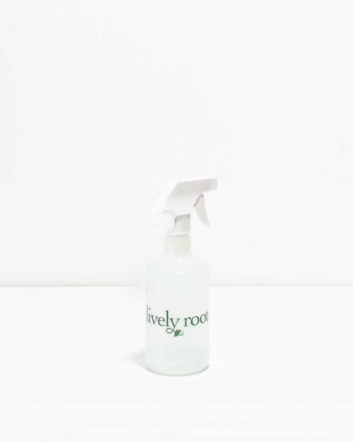 A clear plastic plant mister with a white spray nozzle and a label that reads 'Lively Root'.